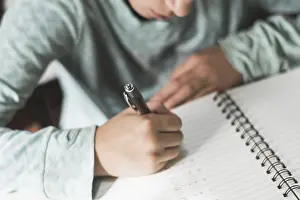 Childhood Learning Experience Drucke: Crop kid writing notebook