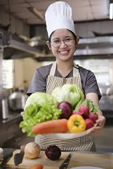 Fresh Ingredients Photography Drucke: A culinary student stands in a professional training kitchen