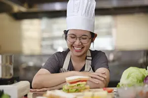 Meal Preparation Drucke: A culinary student stands in a professional training kitchen