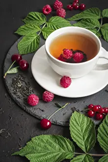 Black Background Cutout Images Drucke: Cup of Berry tea and ripe raspberry