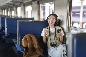 Young Woman On Train Drucke: With a cup of coffee in one hand
