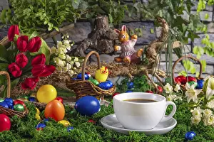 Christian Easter Traditions Drucke: A cup of coffee surrounded by springtime Easter decorations with a background of wood and greenery