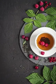Black Background Food Drucke: Cup of tea and ripe raspberry, cherry