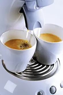 Coffee Cup Close Up Drucke: Two cups placed under an espresso machine