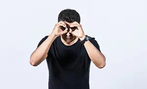 Curious Man Drucke: Curious man making binoculars gesture