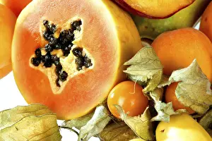 Macro Photography Images Drucke: Cut open papaya and assorted fruit on white background