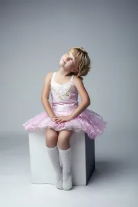 Young Female Dancer Drucke: Cute little dancer posing sitting on cube in studio