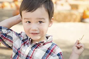 Autumnal Atmosphere Images Drucke: Cute mixed-race young boy having fun at the pumpkin patch