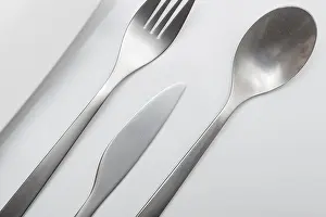 White Table Setting Drucke: Cutlery on white table. Minimal designed fork