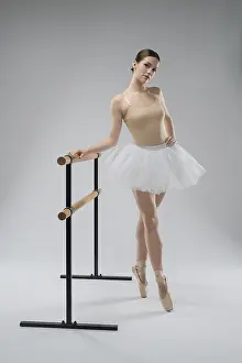 Female Ballet Artist Drucke: A dancer in a light tutu poses elegantly at the barre