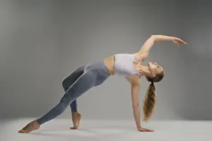 Minimalist Studio Setting Drucke: A dancer performs an impressive flexible pose in a minimalist studio setting