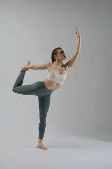 Minimalist Studio Shot Drucke: A dancer showcases her flexibility and strength while executing an elegant pose in a studio