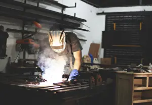Factory Interior Photography Drucke: Deaf man using a welding torch in the workshop