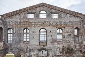 Abandoned Architecture Drucke: Decayed facade of an old brick building with arched windows