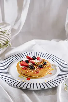 Fruit Topped Pancakes Drucke: Delicious stack of pancakes lying on plate with blue stripes