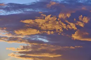 Evening Sun Over Bavaria Drucke: Dense clouds in deep orange and blue in dramatic light in the evening sky