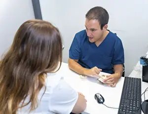 Healthcare Professional Consultation Drucke: Dental clinic, dentist explaining to a client the teeth to be implanted in a model