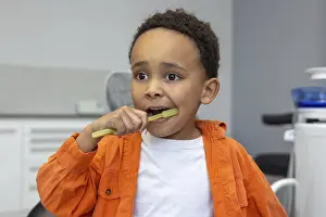 Medical Care For Toddlers Drucke: In dentistry. Dark-skinned boy brushing his teeth