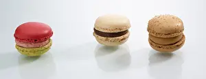 Colorful Desserts Drucke: Three differently coloured macarons in front of a white background