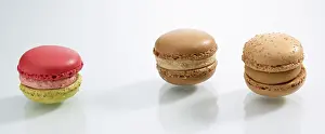 French Dessert Drucke: Three differently coloured macarons in front of a white background