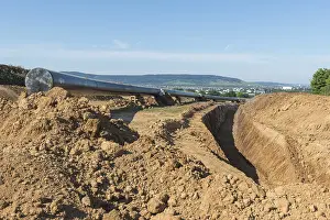 Open Air Landscape Photo Germany Drucke: Digging for a pipeline with landscape in the background