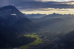 Bavarian Alps Drucke: Distant view of town in front of mountains in the evening light