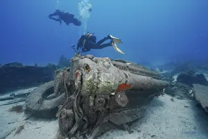 Russian Hydrofoil Wreck Dive Site Drucke: Two divers explore the engine of a large wreck on the seabed