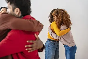 Studio Shot Diversity Drucke: Diverse group embracing in a supportive circle