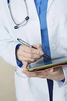 Female Doctor Portrait Drucke: Doctor in white coat makes notes at work