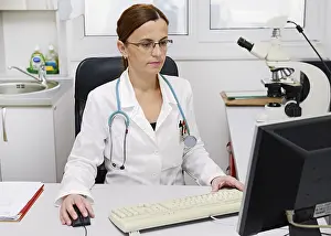 Healthcare System Technology Drucke: Doctor working on a computer at her desk