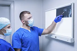 Medical Practitioner Drucke: Two doctors are examining an X-ray
