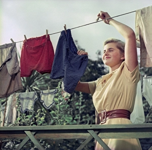 Young Woman Cleaning Drucke: Doing the laundry in the 1950s