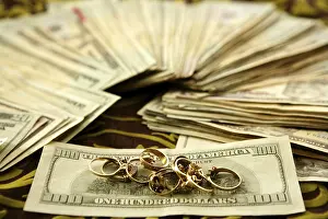 Payment Transaction Drucke: Dollar notes and gold rings over tablecloth