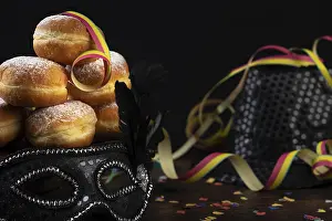 Plain Colored Background Cutout Drucke: Doughnuts against a dark background next to a black hat