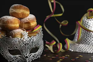 Deserted Carnival Scene Drucke: Doughnuts against a dark background next to a silver hat