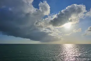 Dramatic Sky UK Drucke: Dramatic cloud formation with solar radiation over the sea