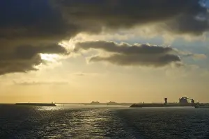 Evening Light In France Drucke: Dramatic clouds and setting sun reflect in calm sea