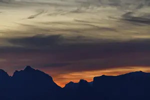 Deserted Mountain Top Views Drucke: Dramatic cloudy sky with mountain peaks at sunrise