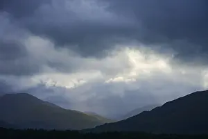 Dramatic Mountain Landscape Drucke: Dramatic mountain landscape under cloudy sky with rays of light