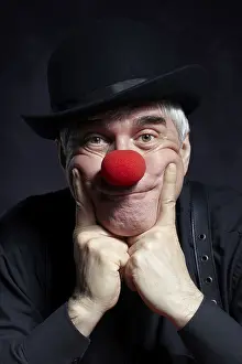 Bilder Datiert 7. April 2024: Dramatische Porträt eines traurigen Clowns vor dunkler Hintergrund.