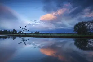 Drucke von Dramatischer stürmischer Sonnenuntergang über niederländische Windmühle am Fluss, Holland Fluss Drucke: Dramatischer stürmischer Sonnenuntergang über niederländische Windmühle am Fluss.