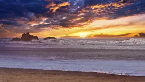 Sunset On The Rocky Shore Drucke: Dramatic sunset on the beach, rocks in the surf