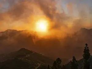 Dramatic Mountain Landscape Drucke: Dramatic sunset lighting up the clouds and mist over the mountains