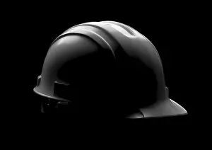 Industrial Equipment Drucke: Dramatically lit hard hat isolated on a black background