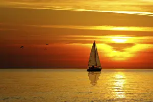 Orange Sunset Sky Drucke: Drifting boat on a sunset