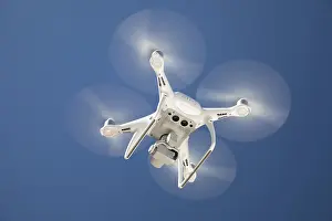 Unmanned Aerial Vehicle Technology Drucke: Drone quadcopter from below against A blue sky