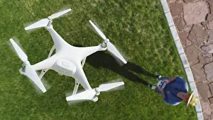 Air Traffic Control Drone Drucke: Drone quadcopter (UAV) in air above pilot with remote controller