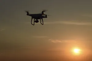 Atmospheric Light Photos Drucke: Drone silhouette against the background of the sunset