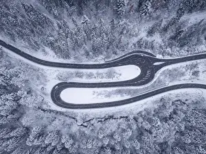 Black Forest Germany Aerial Photography Drucke: Drone view of a sharp bend in a road surrounded by snow-covered trees