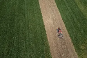 Agricultural Landscape From Above Drucke: Drone view, tractor at work between green fields